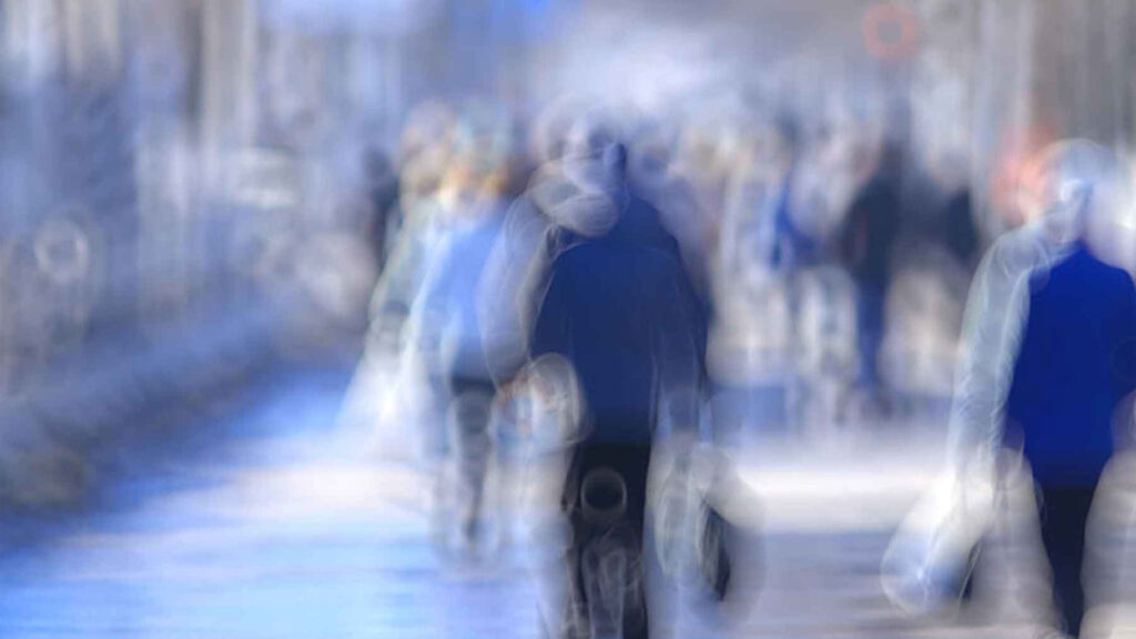 Blurred image of people walking in a city street, creating a dreamy and abstract urban scene.