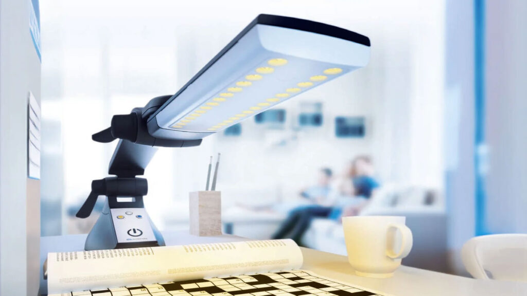 LED desk lamp illuminating a crossword puzzle on a white table with a cup and pencils in a modern office setting.