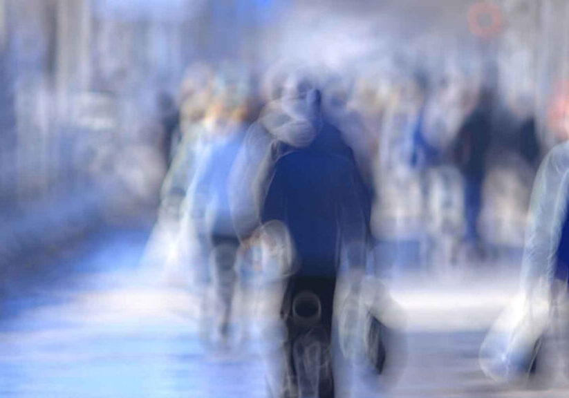 Blurred image of people walking in a city street, creating a dreamy and abstract urban scene.